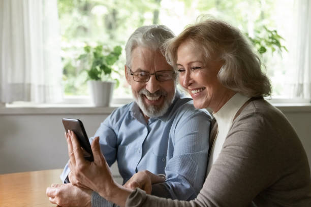 istock Happy mature couple using smartphone for video call from home 1305360020