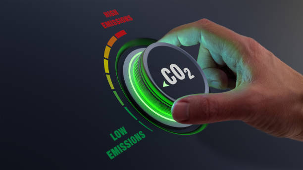 lower co2 emissions to limit global warming and climate change. concept with manager hand turning knob to reduce levels of co2. new technology to decarbonize industry, energy and transport - dióxido de carbono imagens e fotografias de stock