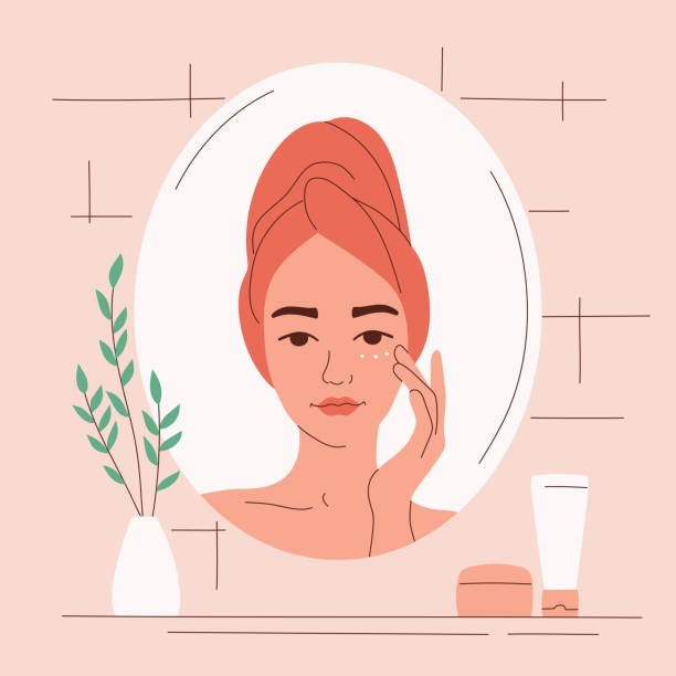 A young woman in the bathroom looks in the mirror and cares for her face with cream. Daily skin hydration. Anti-aging procedure. Clean healthy skin. Vector illustration A young woman in the bathroom looks in the mirror and cares for her face with cream. Daily skin hydration. Anti-aging procedure. Clean healthy skin. Vector illustration square composition aging process illustrations stock illustrations