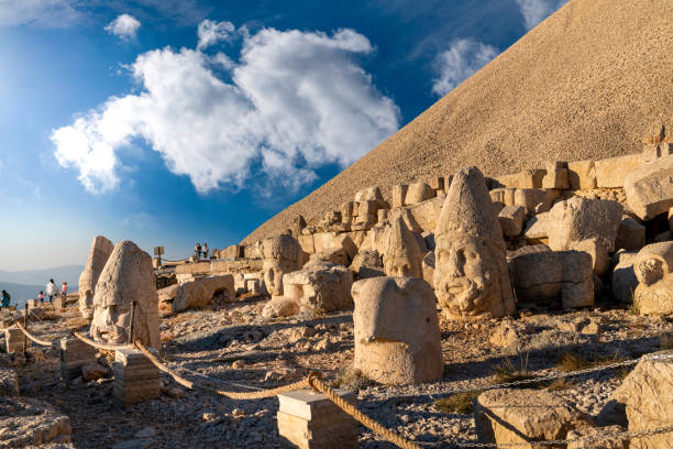 commagene statue ruinen auf dem berg nemrut mit blauem himmel. steinköpfe auf der spitze des 2150 meter hohen mount nemrut. - nemrud dagh mountain turkey history stock-fotos und bilder