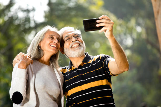 istock Senior couple taking selfie at park 1305363653
