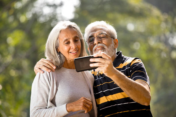 istock Senior couple taking selfie at park 1305363810