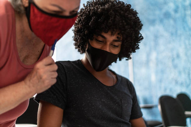 istock Teacher helping student at school - wearing face mask 1305364187