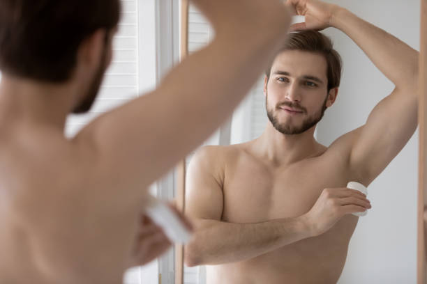 istock Handsome young 30s shirtless man applying deodorant. 1305364221
