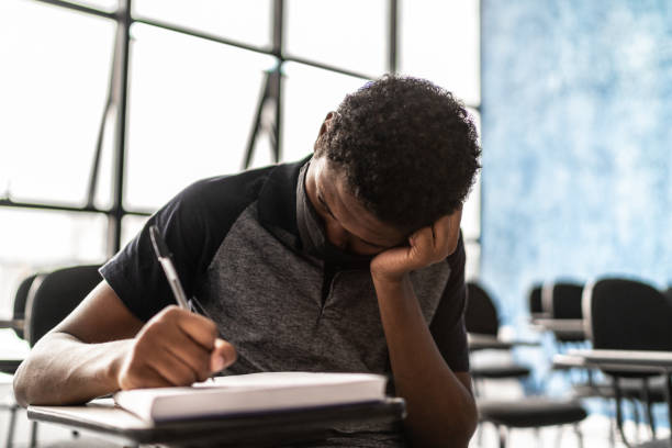 istock Tired student in the classroom - wearing face mask 1305364318