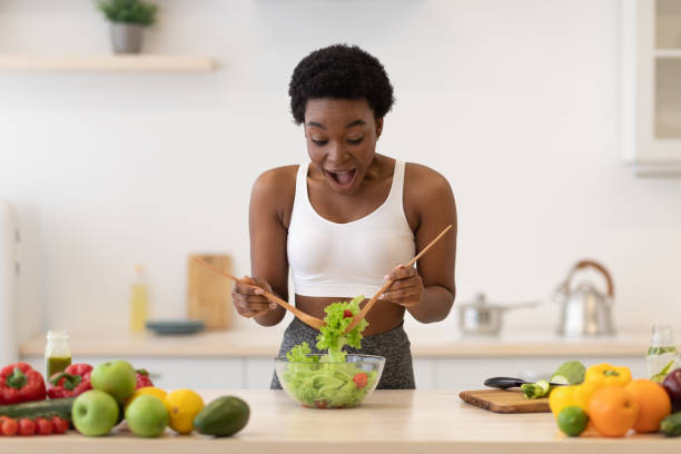 istock Excited African Lady Cooking Healthy Salad Preparing Dinner In Kitchen 1305364649