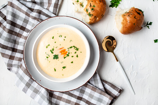 Homemade potato cheese cream soup on a light background, top view.