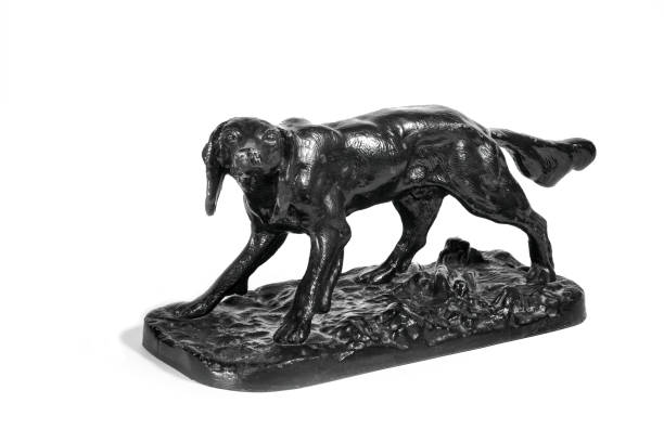 istock Old cast iron figurine of a black dog isolate on a white background. 1305370940