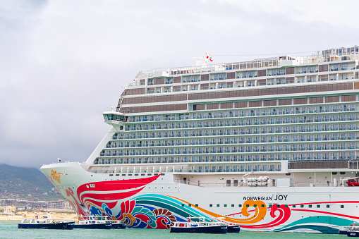Cabo San Lucas, Mexico - October 13 2019: Norwegian NCL Joy Cruise Line Ship docked in Cabo San Lucas, Mexico. Small Tender Boats approach to pick up passengers to carry to the Mexican city shore.