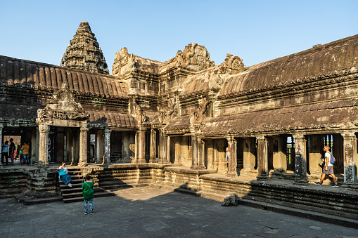 Angkor Wat, Cambodia - January 20, 2020: The third level court of Angkor Wat is lit by the setting Sun. The Angkor Wat is a Hindu temple complex in Cambodia and is the largest religious monument in the world.