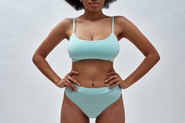 cropped shot of perfect voluptuous young woman wearing blue underwear posing for camera, standing isolated over light background - underwear imagens e fotografias de stock