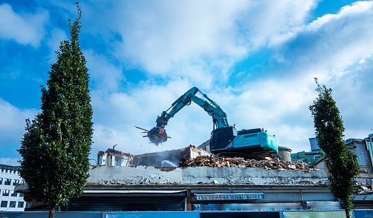 Demolition of building. Excavator breaks old house. Making space for the construction of a new houses