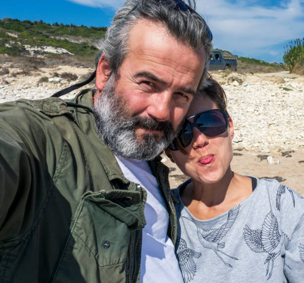 istock Middle aged couple taking selfie by the sea 1305380944