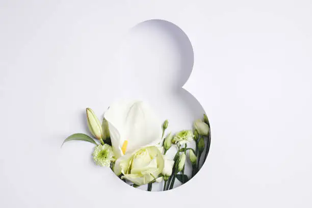 Number 8 with fresh gerbera, calla and rose flowers with green leaves on bright white background. Minimal Women's day, March 8th or birthday concept. Flat lay, top view.