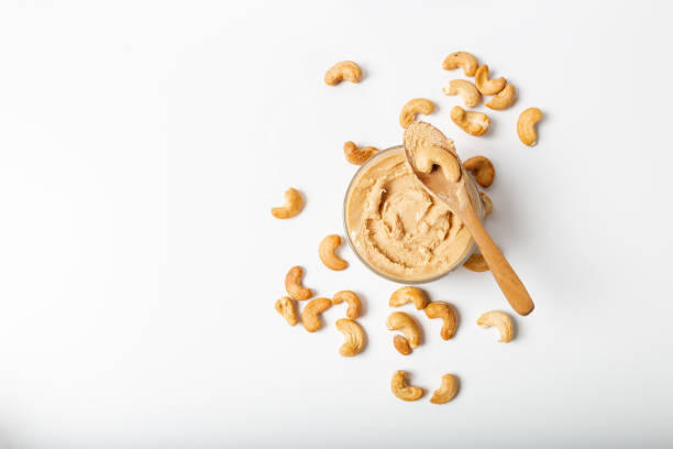 Jar of cashew butter with cashew nuts on the white  background Jar of cashew butter with cashew nuts on the white  background cashew stock pictures, royalty-free photos & images