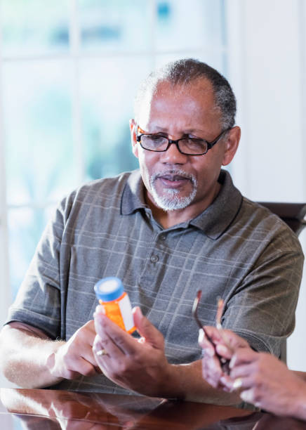 istock Senior man at home reading prescription bottle label 1305385090