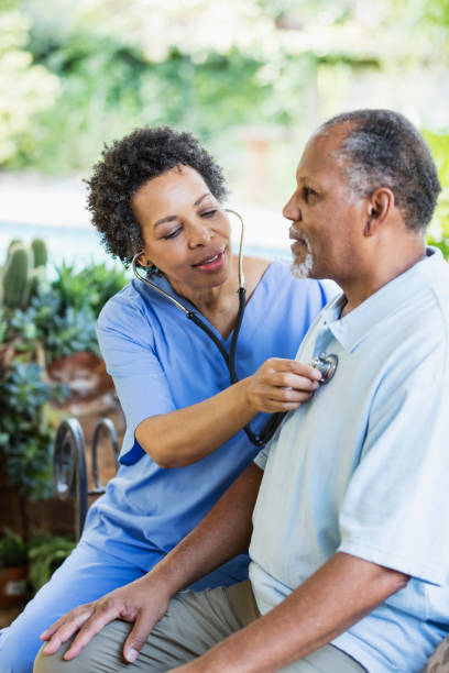 istock Home health aide with senior patient, using stethoscope 1305385274