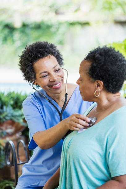 istock Home health aide with senior patient, using stethoscope 1305385302