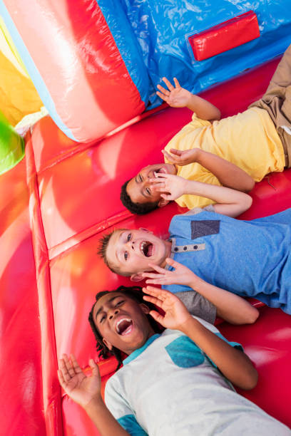 istock Multi-ethnic boys playing in bounce house 1305387053