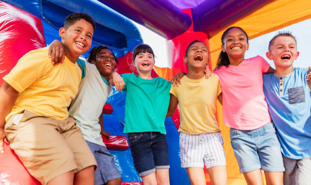 istock Multi-ethnic children in a bounce house 1305387193