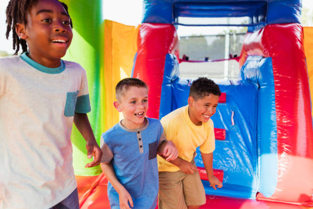 istock Multi-ethnic boys playing in bounce house 1305387221