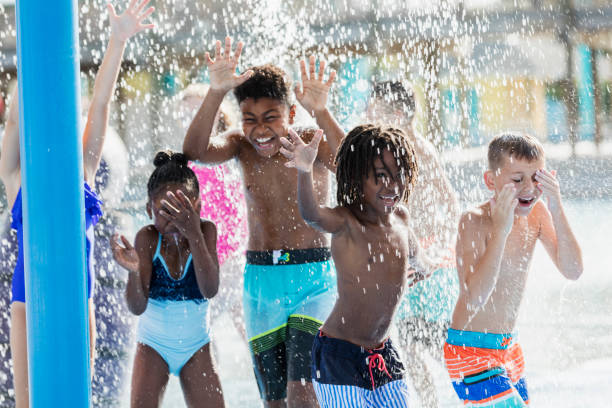 istock Group of children playing at a water park 1305388445
