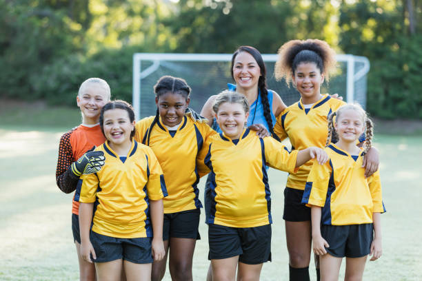 mädchenfußballmannschaft, spieler und trainer - soccer child coach childhood stock-fotos und bilder