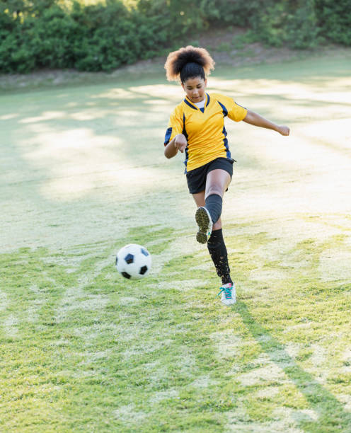istock Girl playing soccer, passing the ball 1305388637