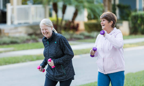 istock Two senior women walking with hand weights, laughing 1305390230