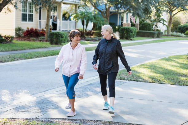 istock Two senior women chatting as they exercise on driveway 1305390302
