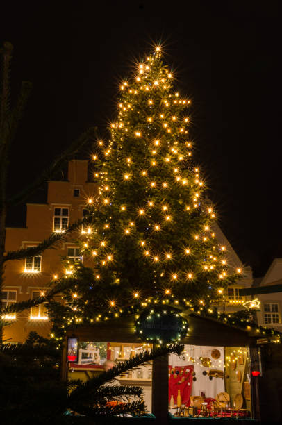 istock illuminated christmas tree at german christmas market with sales booth 1305391495