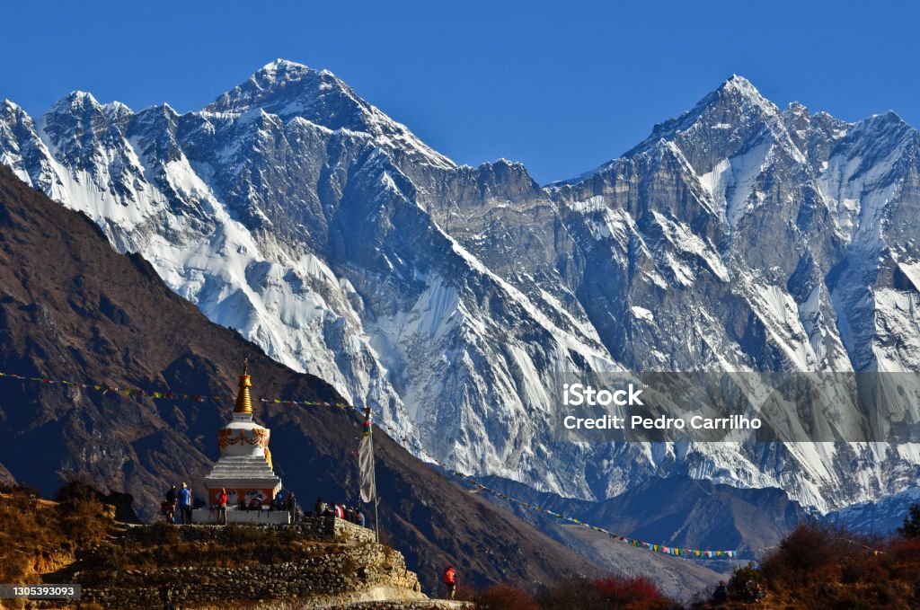Spiritual Himalayas Trekkers stop by a buddhist stupa to rest and enjoy the view of Mount Everest (8.848m) and Lhotse (8.516m) on the way to its Base Camp, Sagarmatha National Park, Solukhumbu, Nepal Mt. Everest Base Camp Stock Photo
