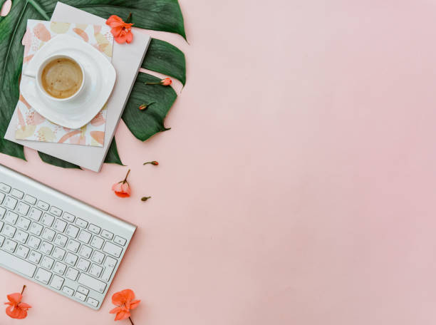 istock Freelancer home office desk workspace with keyboard and coffee cup on pink background. Flat lay, top view still life concept 1305394534