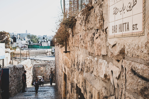 Jerusalem - October 20, 2010: Early morning view on Bab Hutta Street in the Muslim Quarter of Jerualem's Old City. Visible in the distance is the bell tower of Augusta Victoria.