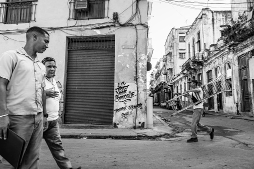 Pedestrians, including a man carrying a ladder, in Havana, Cuba on December 4, 2014.