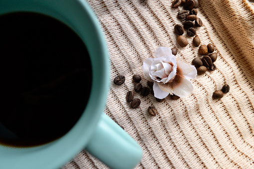 cup of coffee on knitted cloth next to coffee beans in Kropyvnytskyi, Kirovohrad Oblast, Ukraine