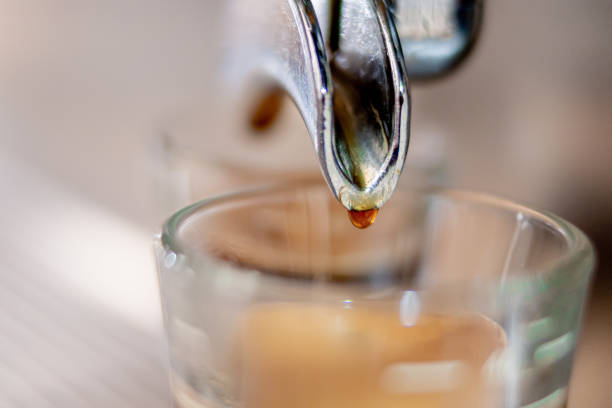 istock Coffee machine dripping on a glass in close up concept. 1305398824