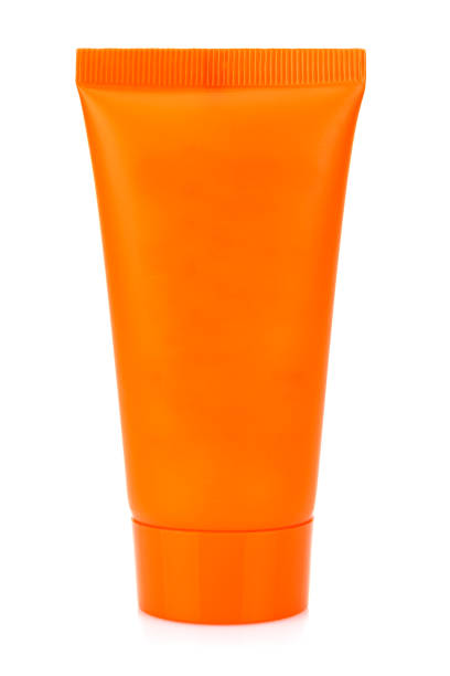 istock Standing on cap blank orange plastic tube for cosmetics cream isolated on white background 1305403079