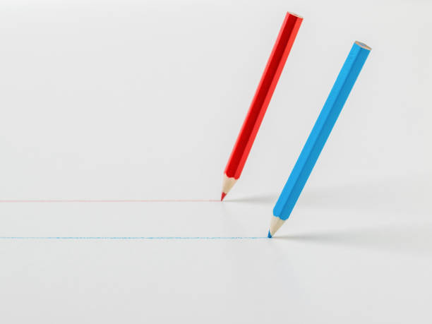 istock Two colored pencils drawing straight lines on a white background. 1305415226