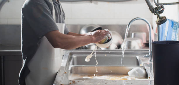 Man washing dish Man washing dish in sink at restaurant.People are washing the dishes too Cleaning solution dishwasher stock pictures, royalty-free photos & images