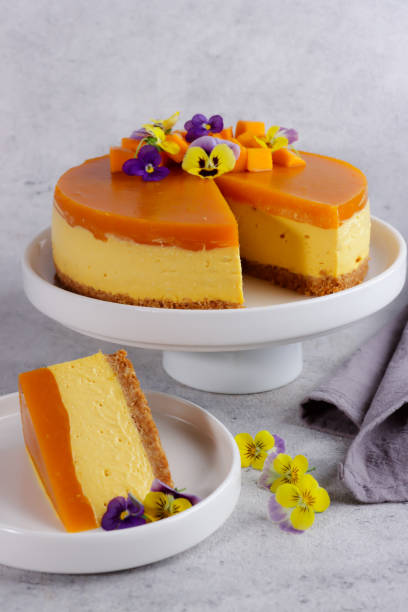 istock Delicious mango cheesecake topping with mango slices and edible flower, close-up, copy space 1305417596