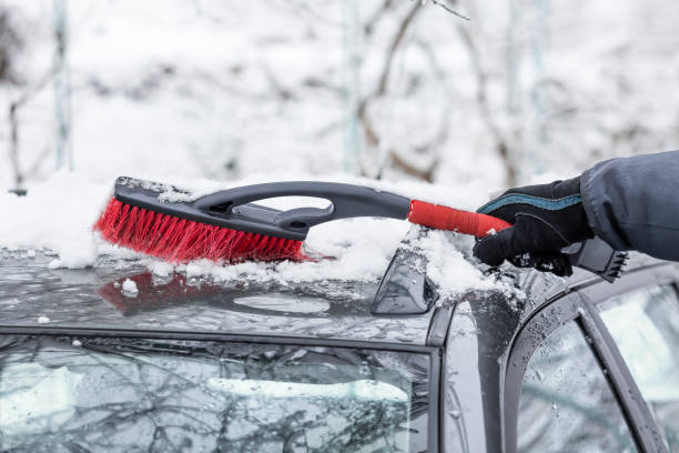 istock A man cleans his car from snow with a brush 1305419053