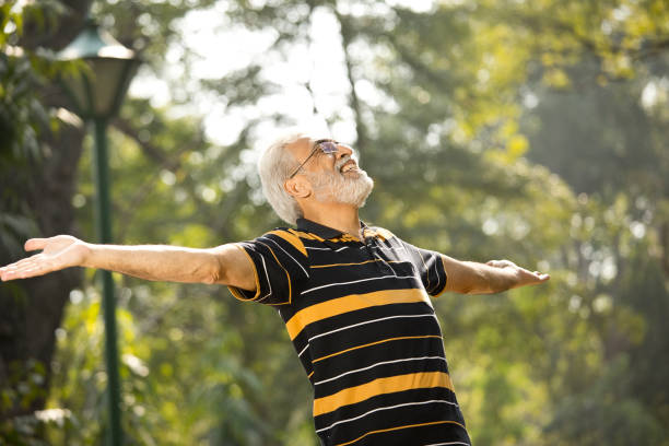 istock Senior man with arms outstretched at park 1305419154