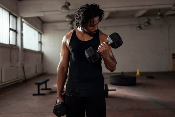 travailler sur ses biceps - men weight training african descent male photos et images de collection