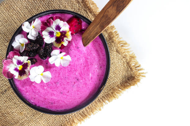 Dragon fruit Lassi, yogurt or smoothie with dragon fruit garnish with edible flowers. Healthy probiotic cold summer food Dragon fruit Lassi, yogurt or smoothie with dragon fruit garnish with edible flowers. Healthy probiotic cold summer food edible flower stock pictures, royalty-free photos & images