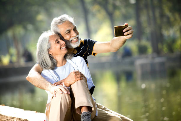 istock Senior couple taking selfie at lakeshore 1305421879