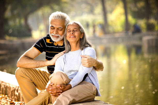 любящая старшая пара, отдыхая на берегу озера - aging process morning outdoors horizontal стоковые фото и изображения