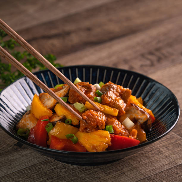 istock Sweet and sour sauced deep fried pork with chopped pepper and pineapple. 1305426068