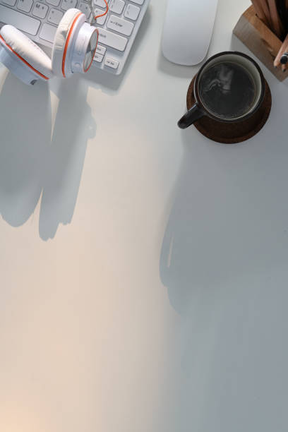 istock Overhead view of comfortable office desk with head coffee cup, and copy space on white background. 1305426340