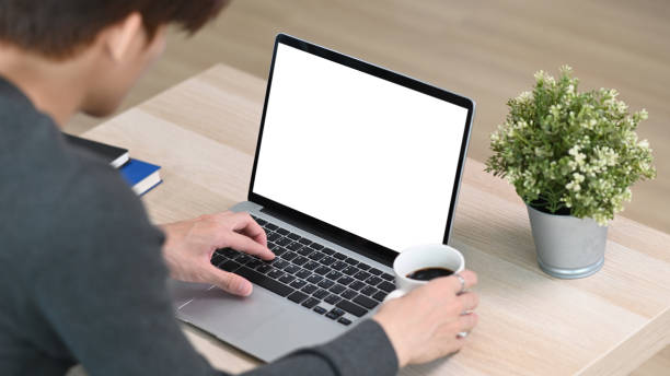 istock Young man freelancer checking email on laptop computer and drinking coffee in the morning at home. 1305427940